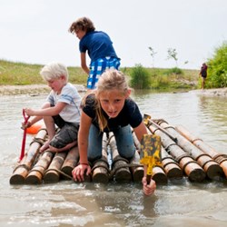 kinderen spelen met een vlot op het water